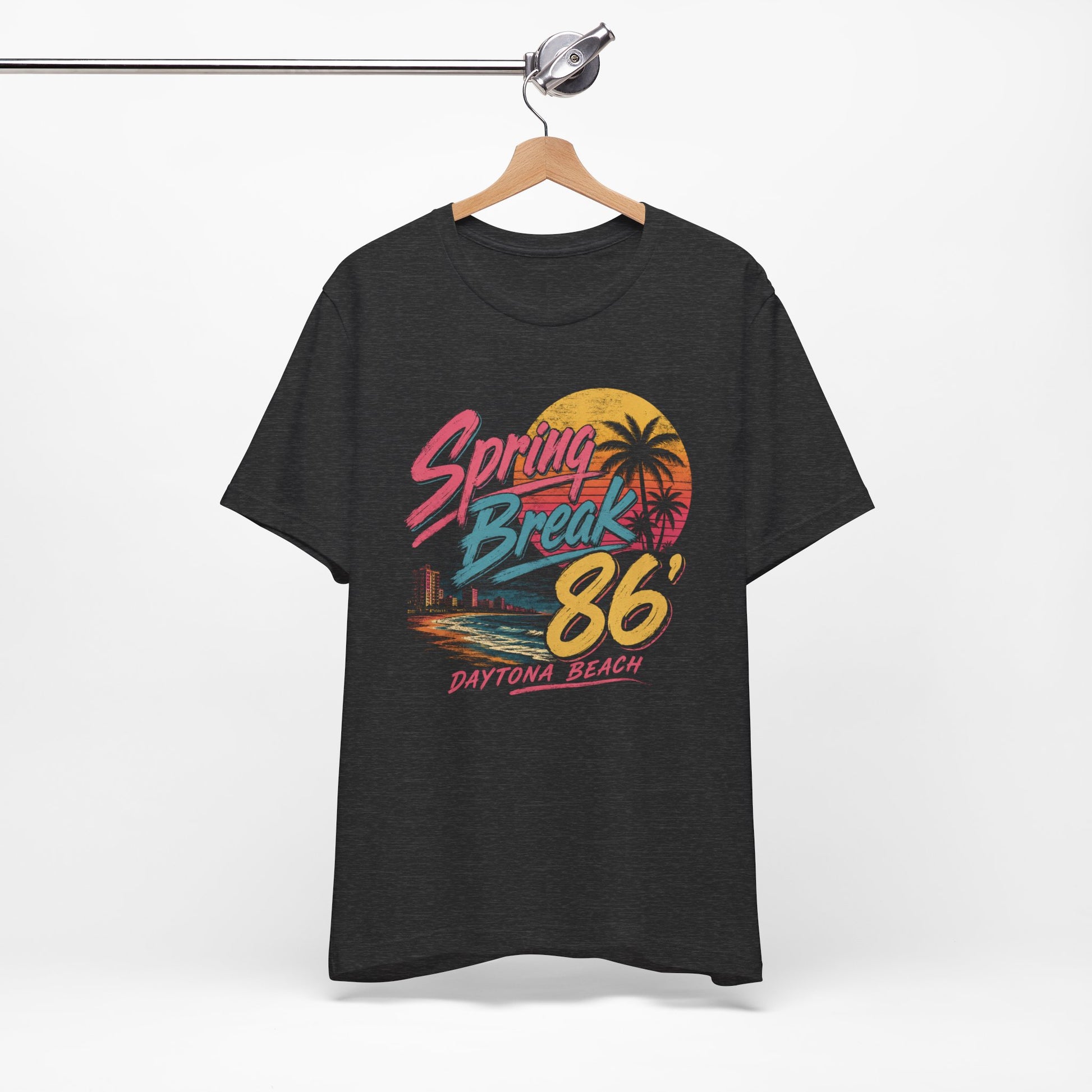 A heather gray t-shirt featuring a colorful retro graphic that reads 'Spring Break 86' and 'Daytona Beach' with a sunset and palm tree design.