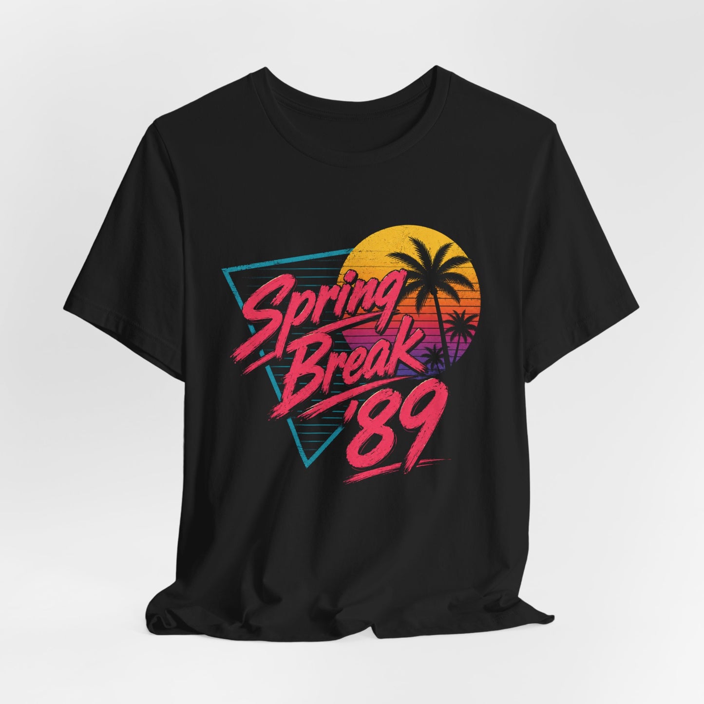 A black short-sleeve t-shirt with a colorful retro graphic on the front that reads 'Spring Break '89' in pink and orange text over a yellow, orange, and purple sunset with palm tree silhouettes.