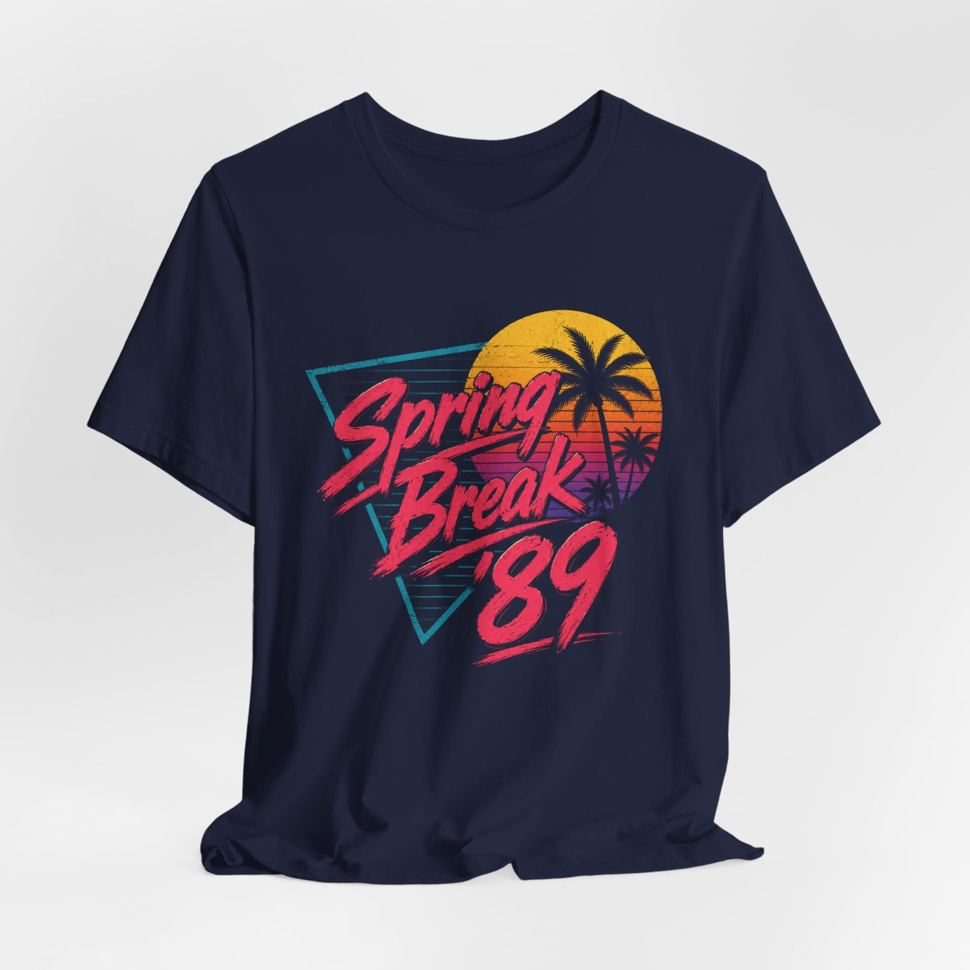 A navy blue short-sleeve t-shirt with a retro 1980s-themed graphic on the front that reads 'Spring Break '89' in pink and orange, featuring a yellow and orange sunset with palm tree silhouettes.