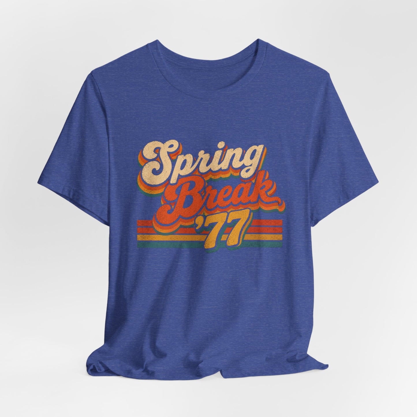 A heather blue short-sleeve t-shirt with a retro-style 'Spring Break '77' graphic on the chest.