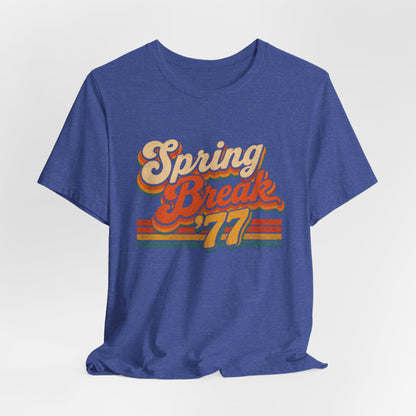 A heather blue short-sleeve t-shirt with a retro-style 'Spring Break '77' graphic on the chest.