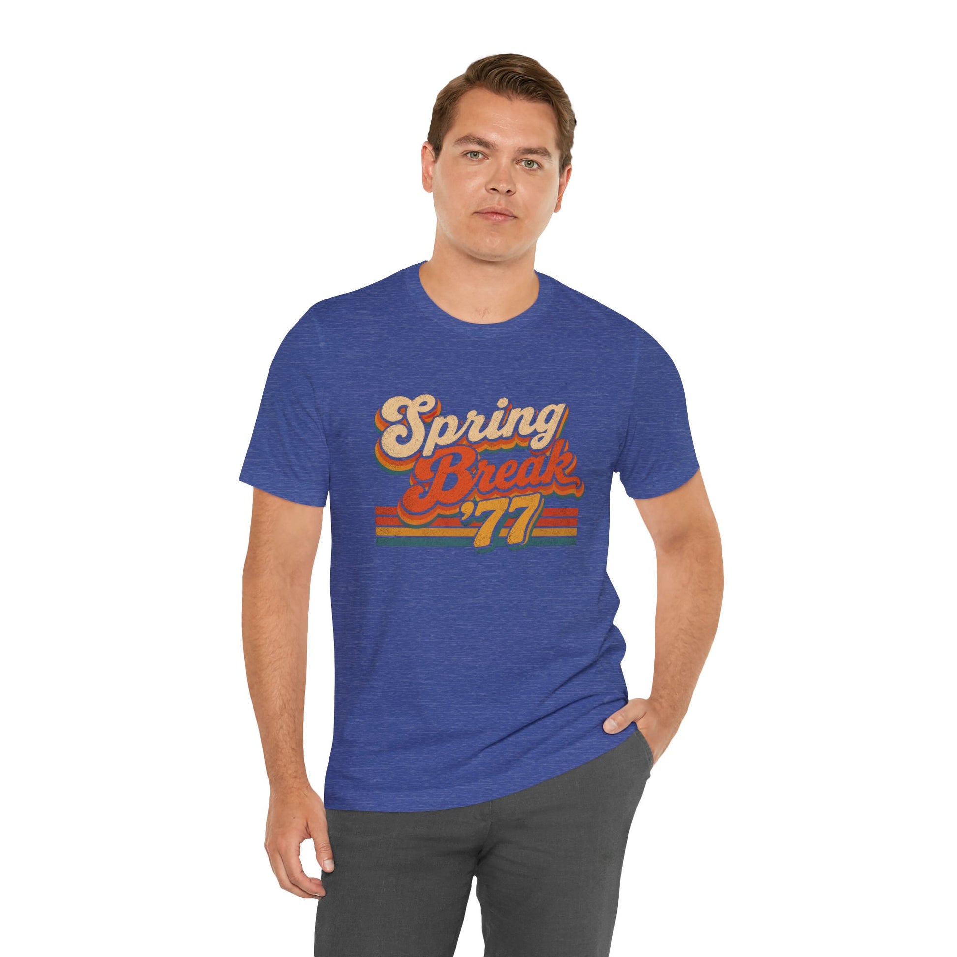 A man wearing a heather blue t-shirt with a retro-style 'Spring Break '77' graphic on the chest.
