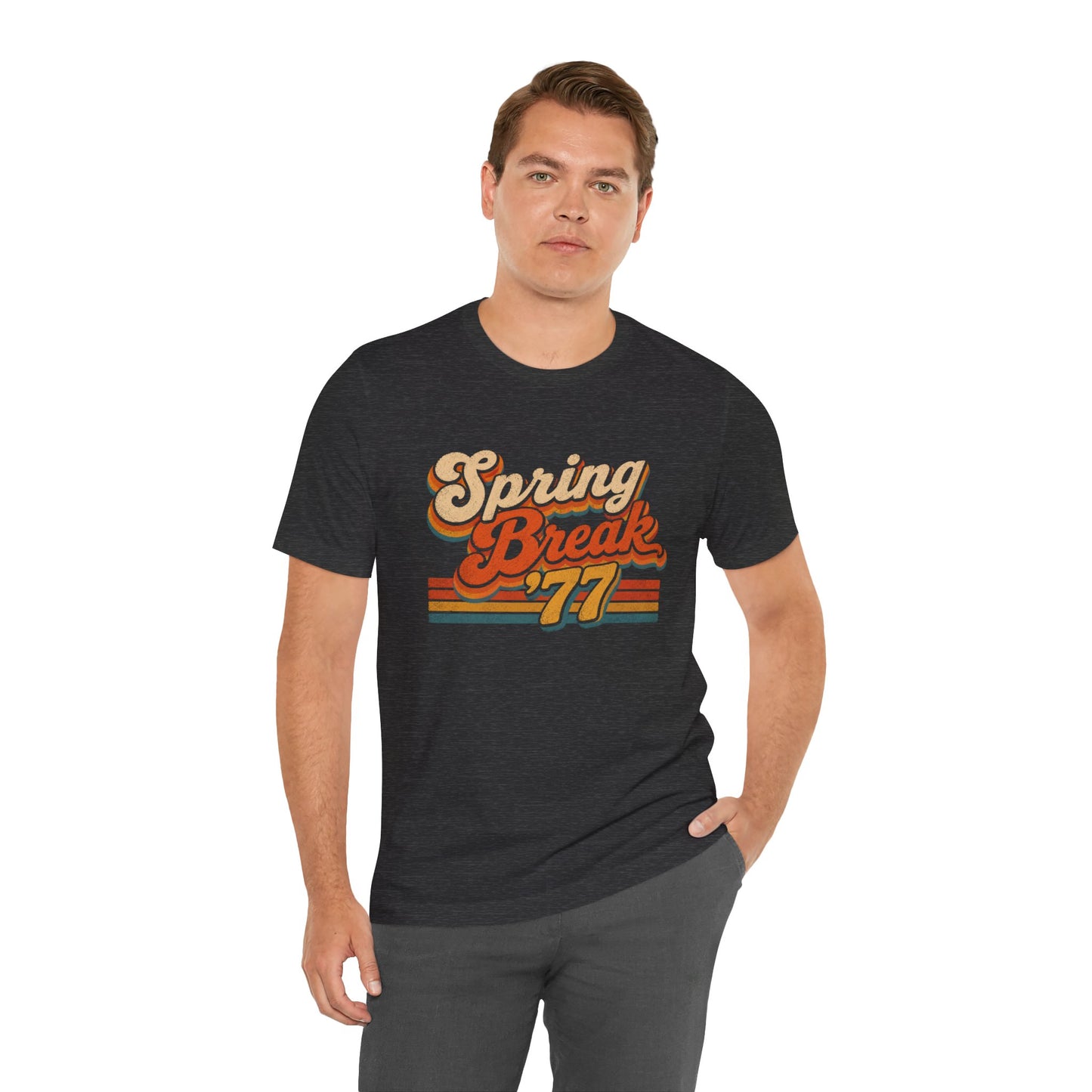 A man wearing a dark heather gray t-shirt with a retro-style 'Spring Break '77' graphic in orange, yellow, and red.