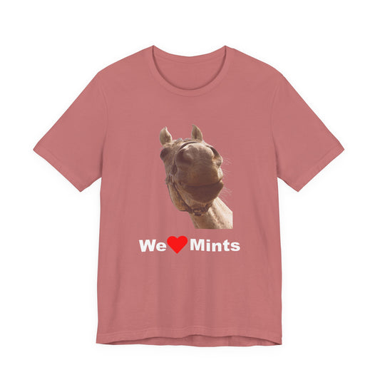 A heather pink short-sleeve t-shirt featuring a graphic of a horse's face above the text 'We Love Mints'.