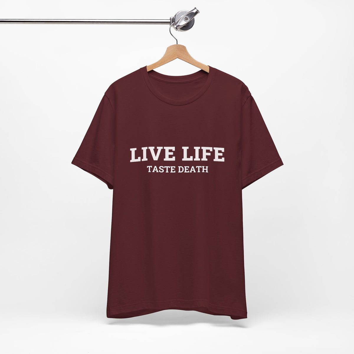 Maroon t-shirt with text quoted from 1990 Movie Ski Patrol, "Live Life Taste Death" in white.
