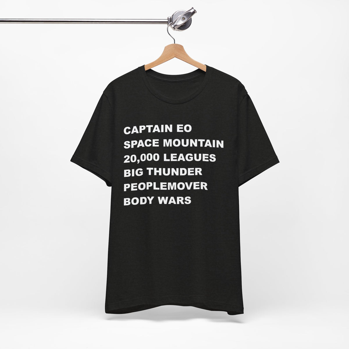 A black short-sleeve crewneck t-shirt with bold white text on the front listing old retro disney rides.