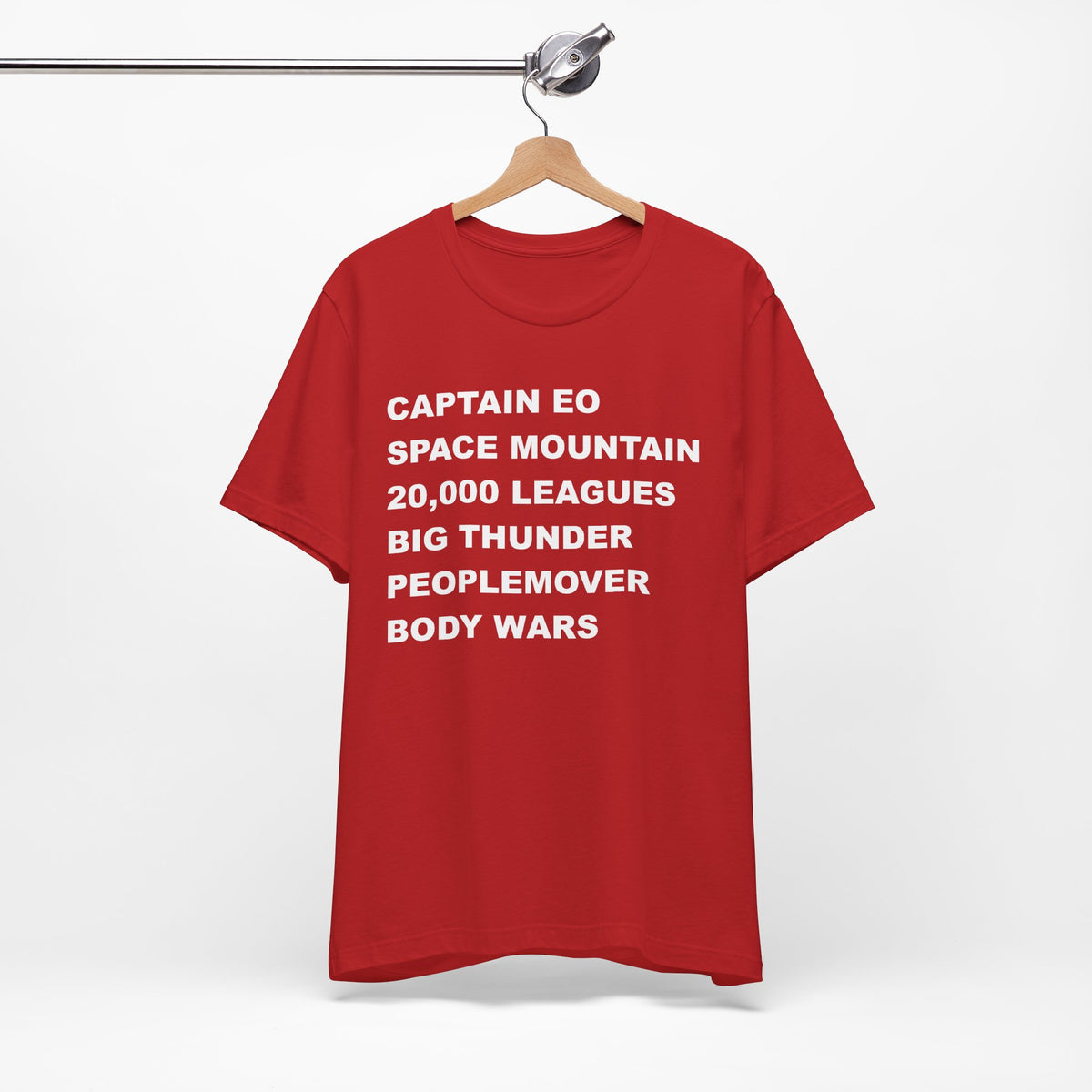 A red short-sleeve crewneck t-shirt with bold white text on the front listing old retro disney rides.