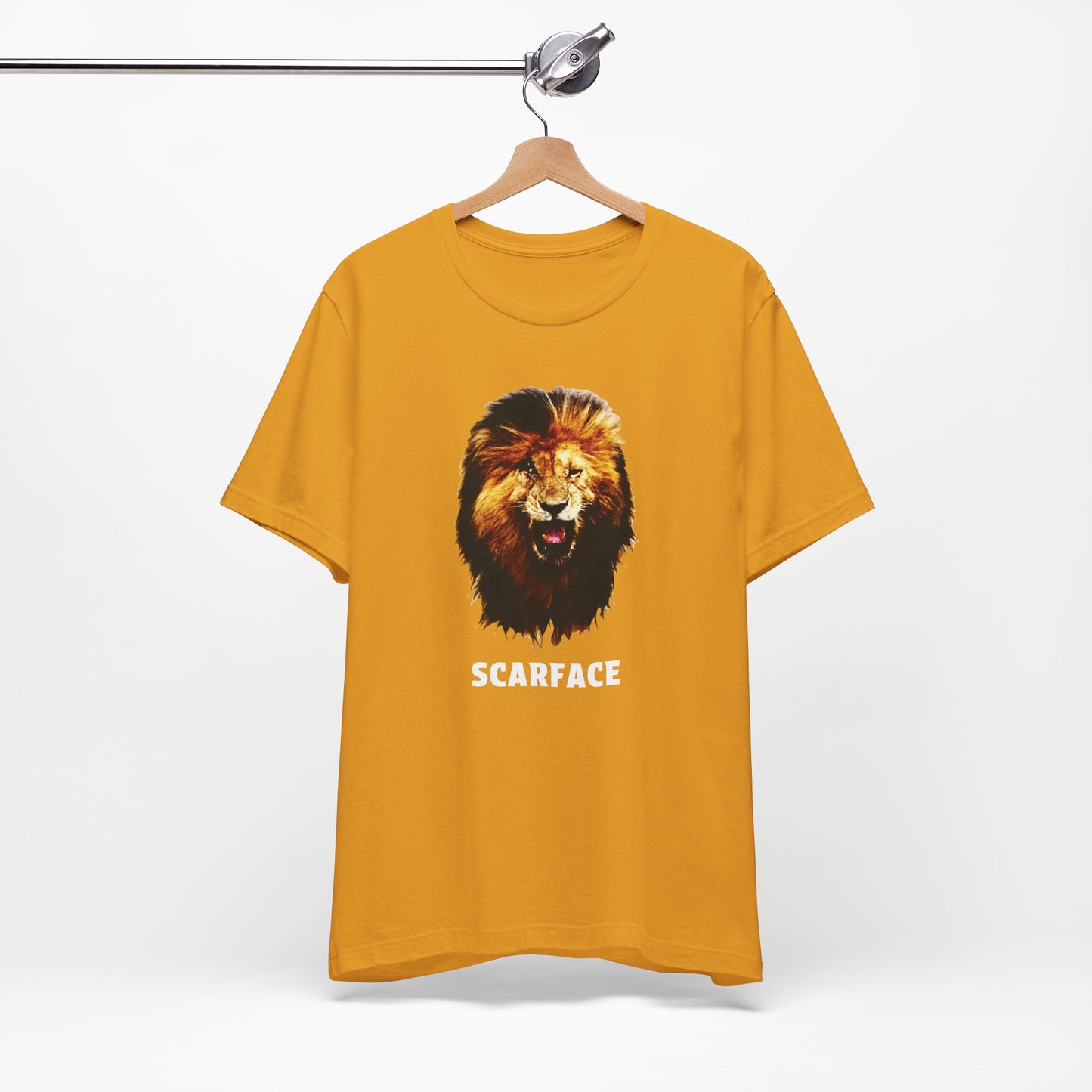 A mustard short-sleeve t-shirt featuring a graphic of a roaring lion's head with the word 'SCARFACE' printed in white below it.