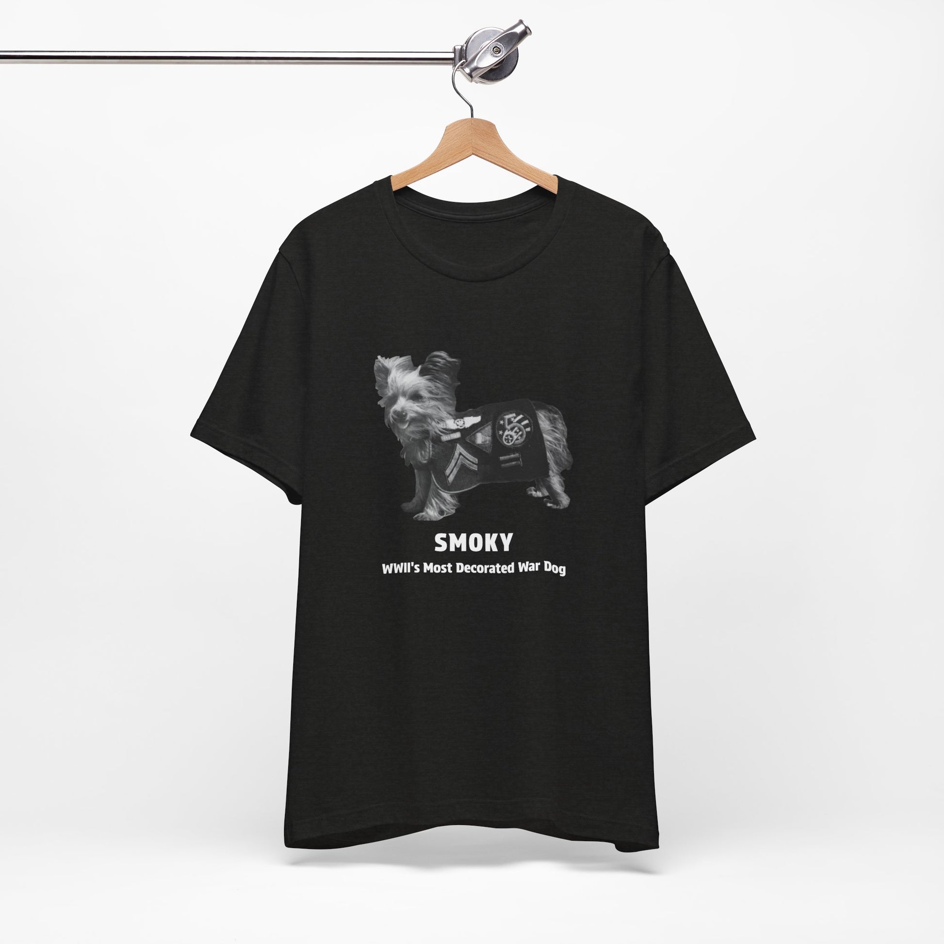 A black short-sleeve t- shirt features a grayscale graphic of a dog wearing a military combat coat with the text 'SMOKY' and 'WII'S MOST Decorated War Dog' printed below.