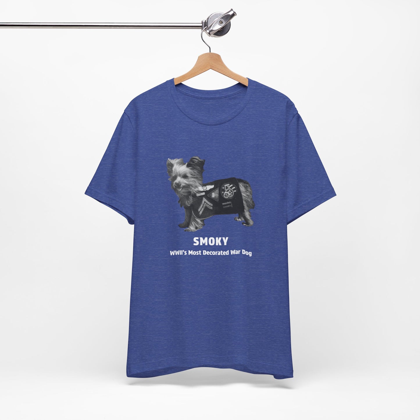 A heather blue short-sleeve t-shirt  featuring a black and white graphic of a dog wearing a military coat with the text 'SMOKY WWII'S MOST DECORATED WAR DOG'.