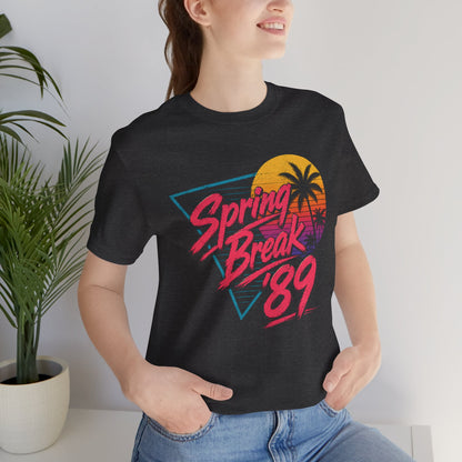 A crewneck t-shirt featuring a colorful retro graphic on the front that reads 'Spring Break 89' with a sunset and palm tree design.