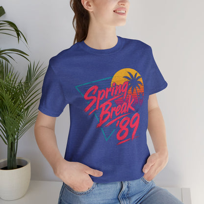 A crewneck t-shirt featuring a colorful retro graphic on the front that reads 'Spring Break 89' with a sunset and palm tree design.